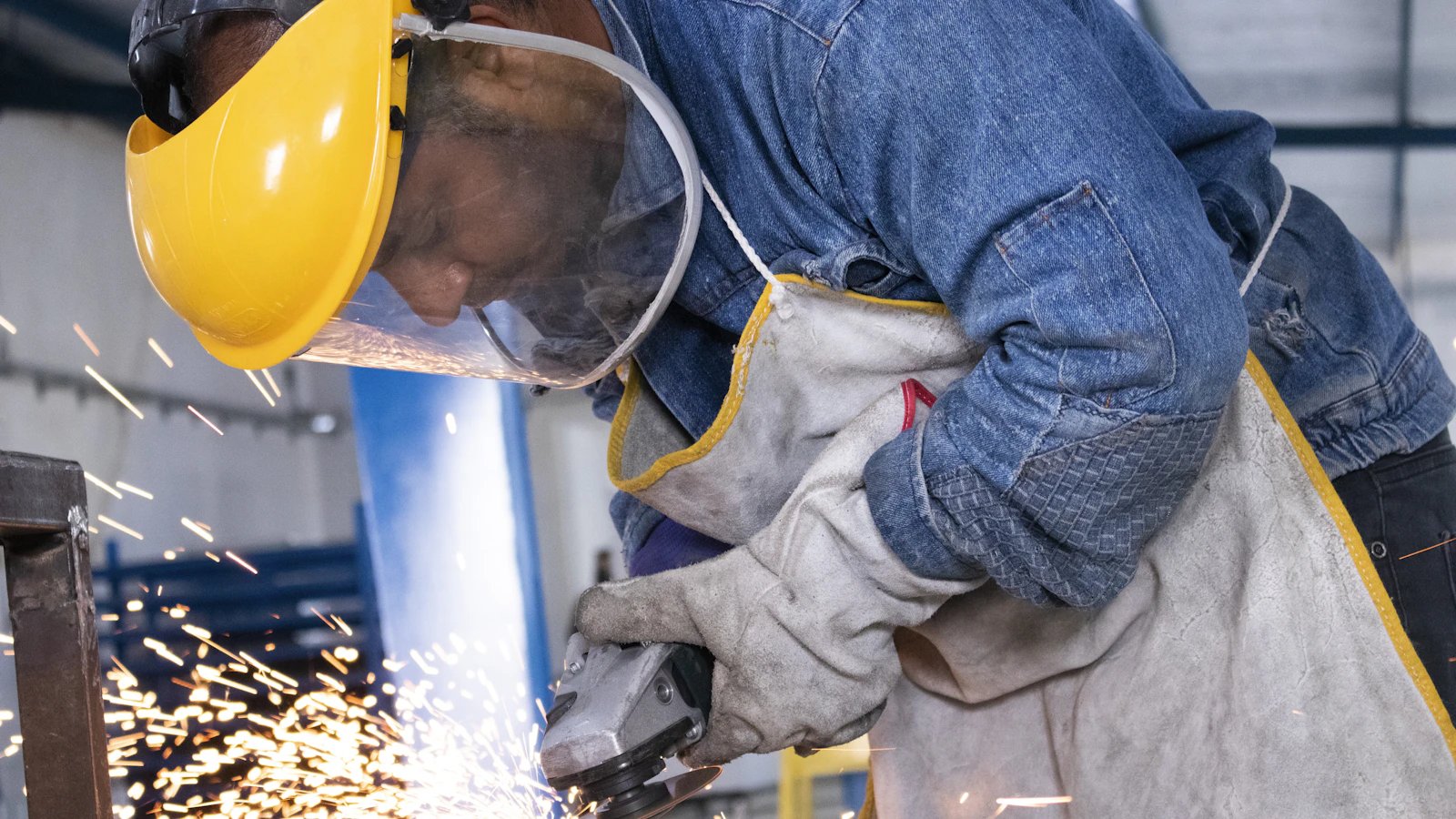 person in blue denim jeans and white and gray gloves holding yellow plastic bucket