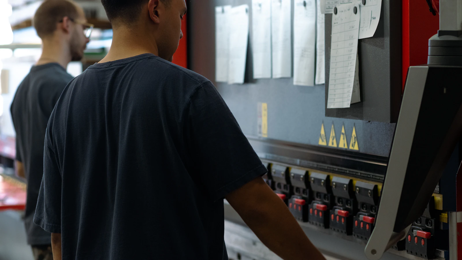two men working on a machine in a factory