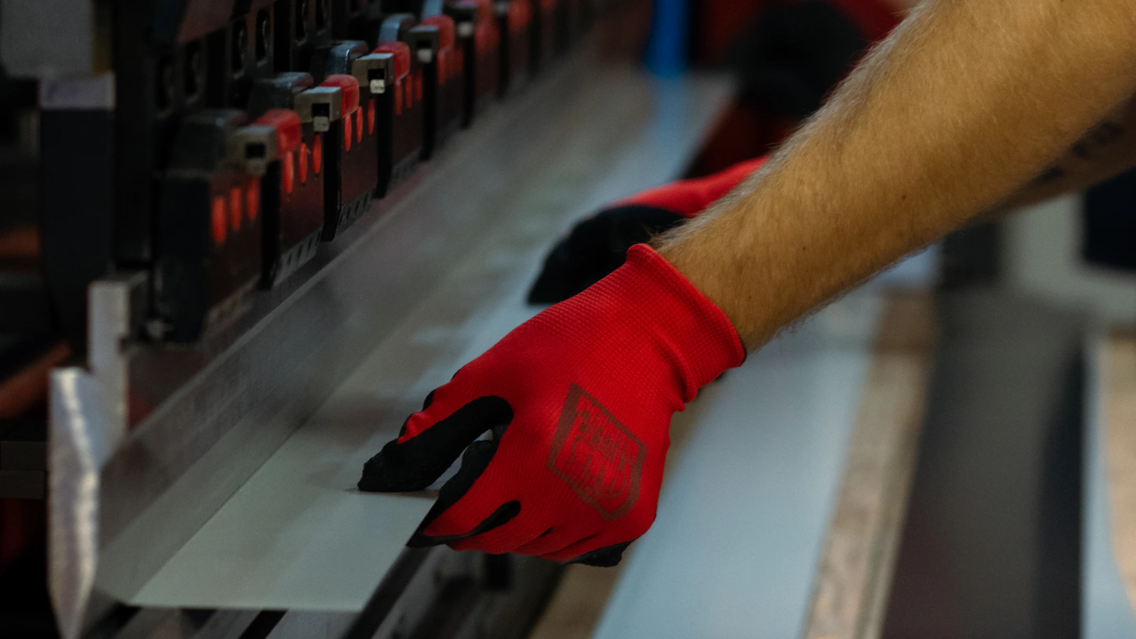 a man wearing red gloves is working on a machine