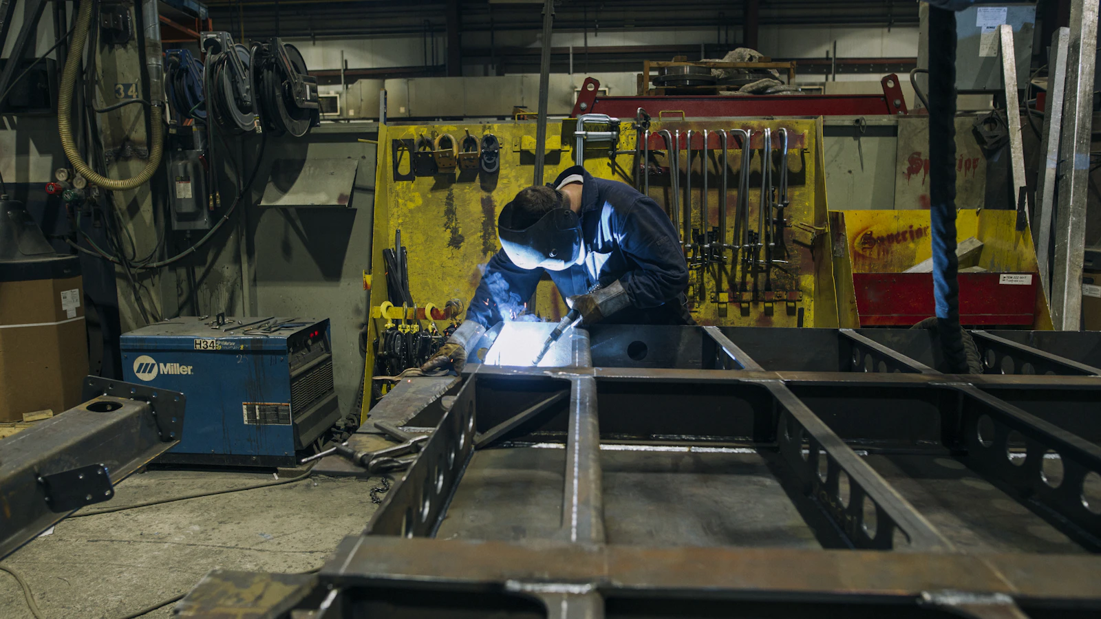 a man in a factory working on a piece of metal