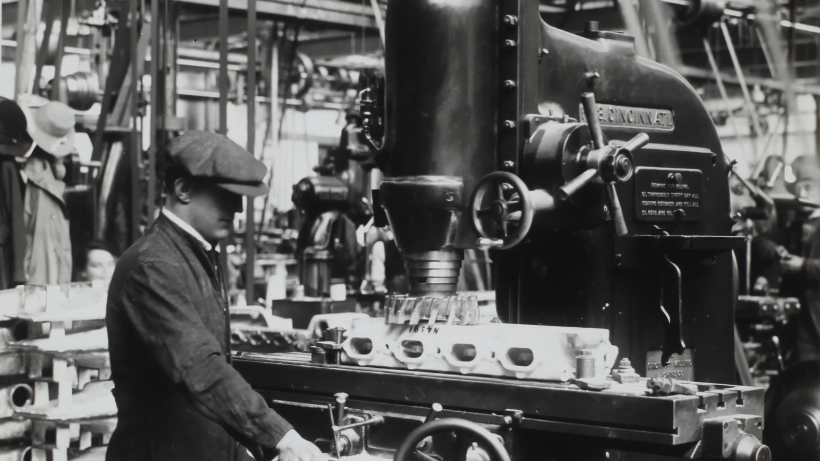 grayscale photography of man facing mechanical machine