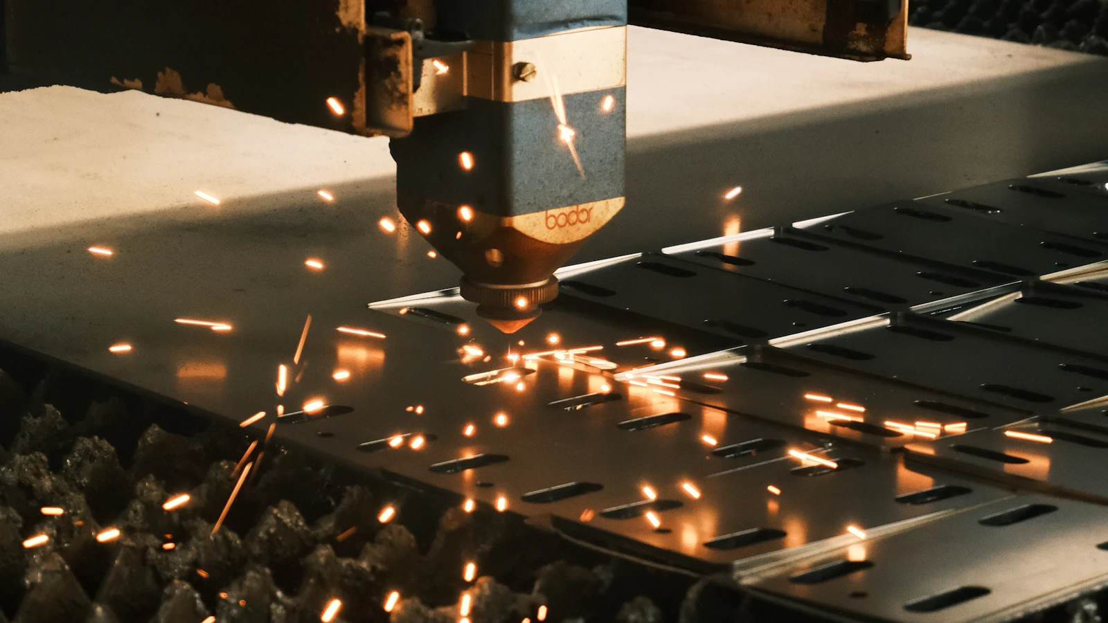 A machine cutting a piece of metal with sparks