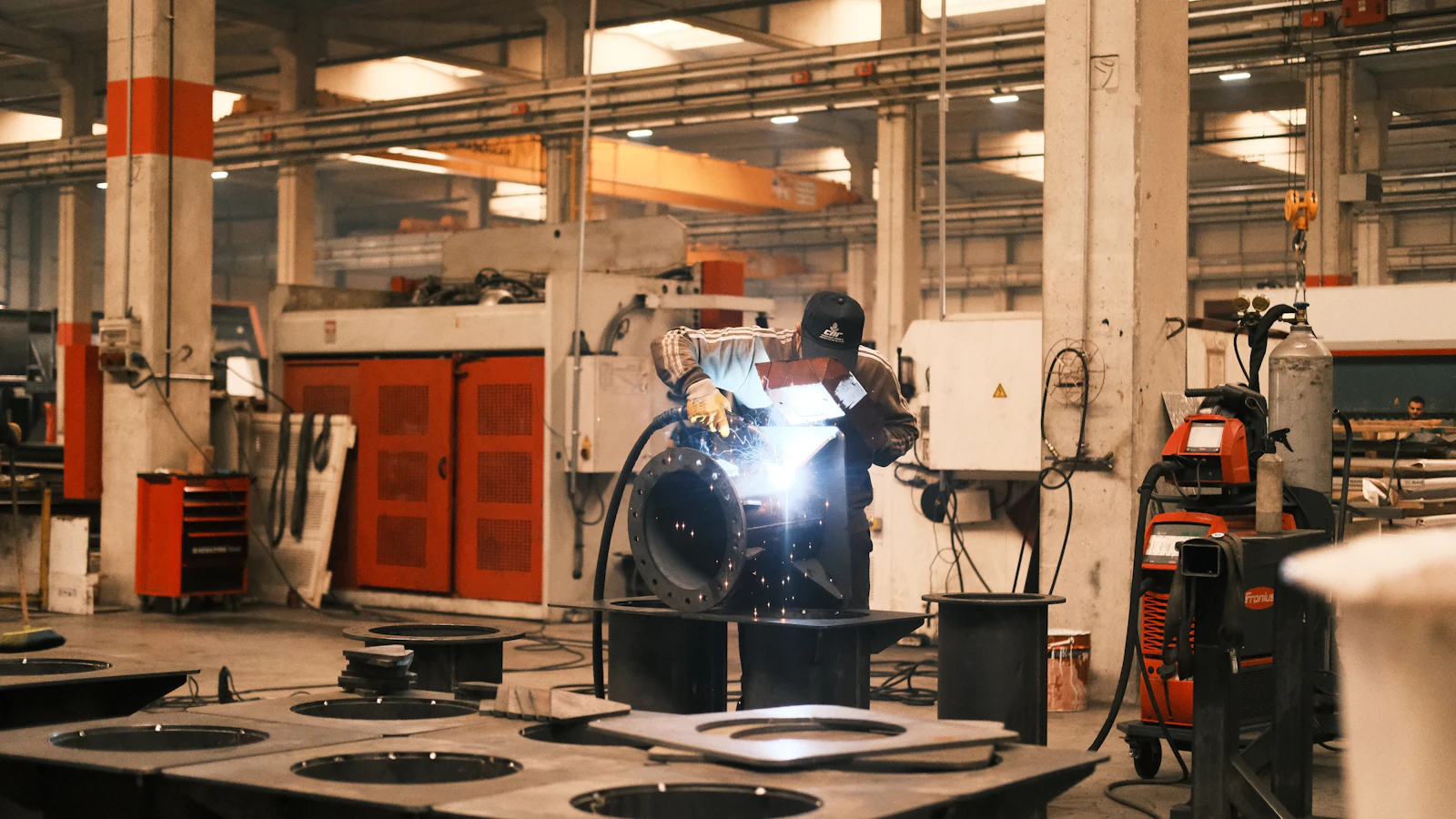 A man welding a piece of metal in a factory