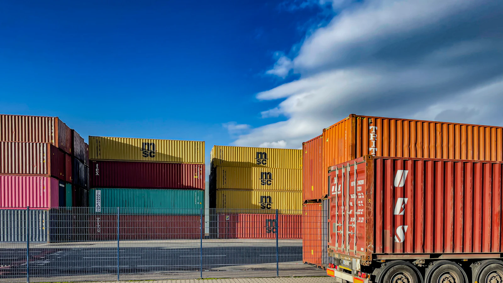 a truck is parked in front of a bunch of shipping containers