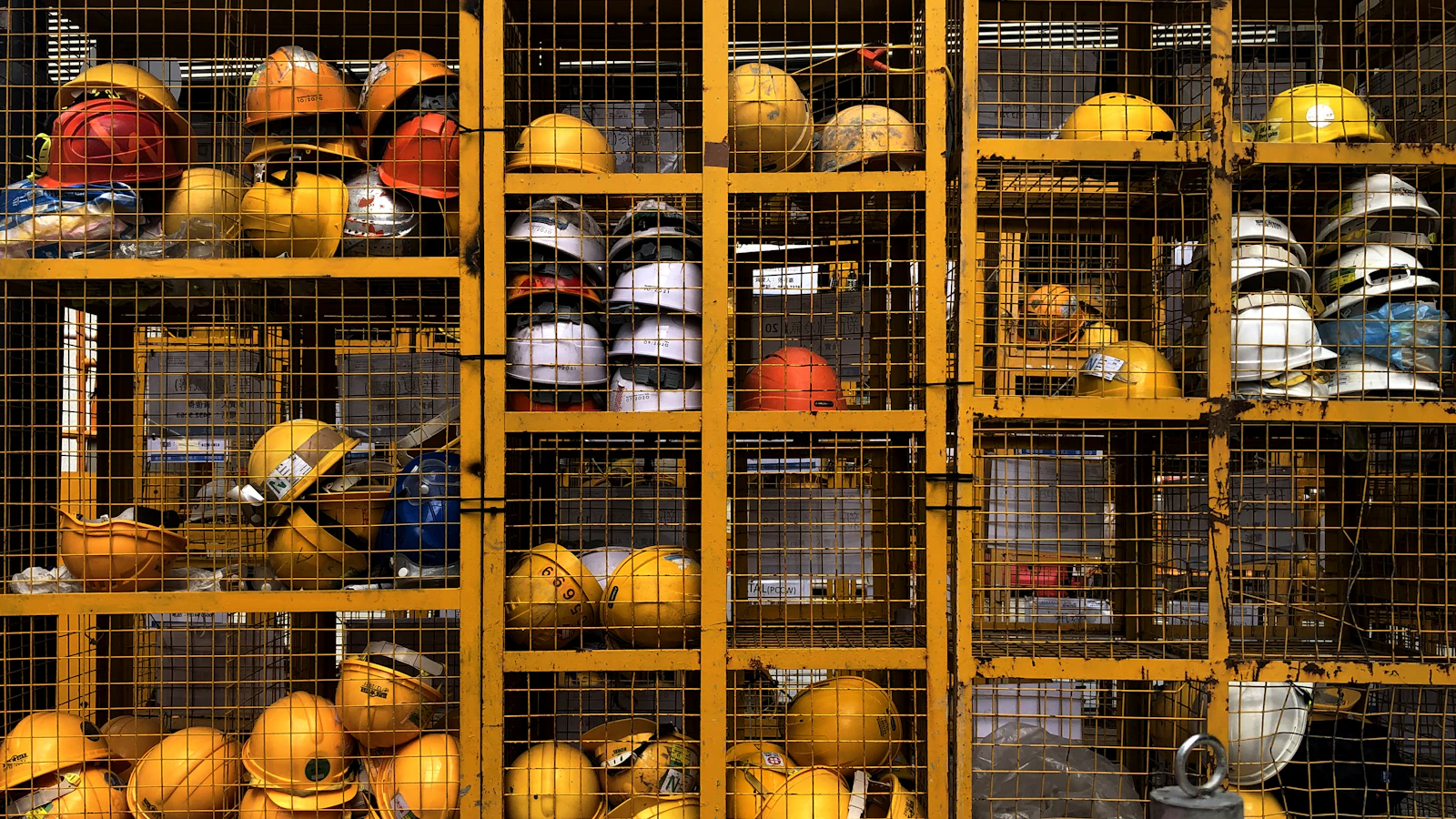 a rack filled with lots of yellow hard hats