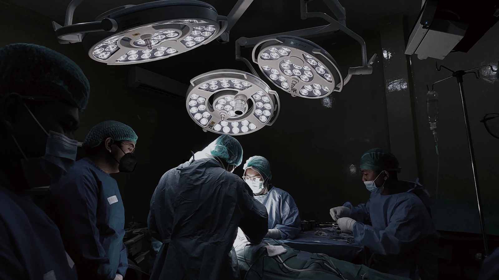A group of doctors standing around a hospital bed