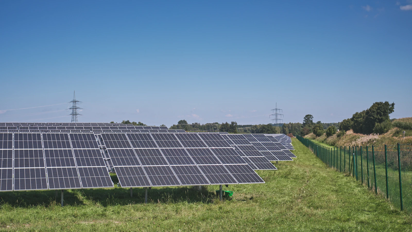 solar panels on green grass field under blue sky during daytime