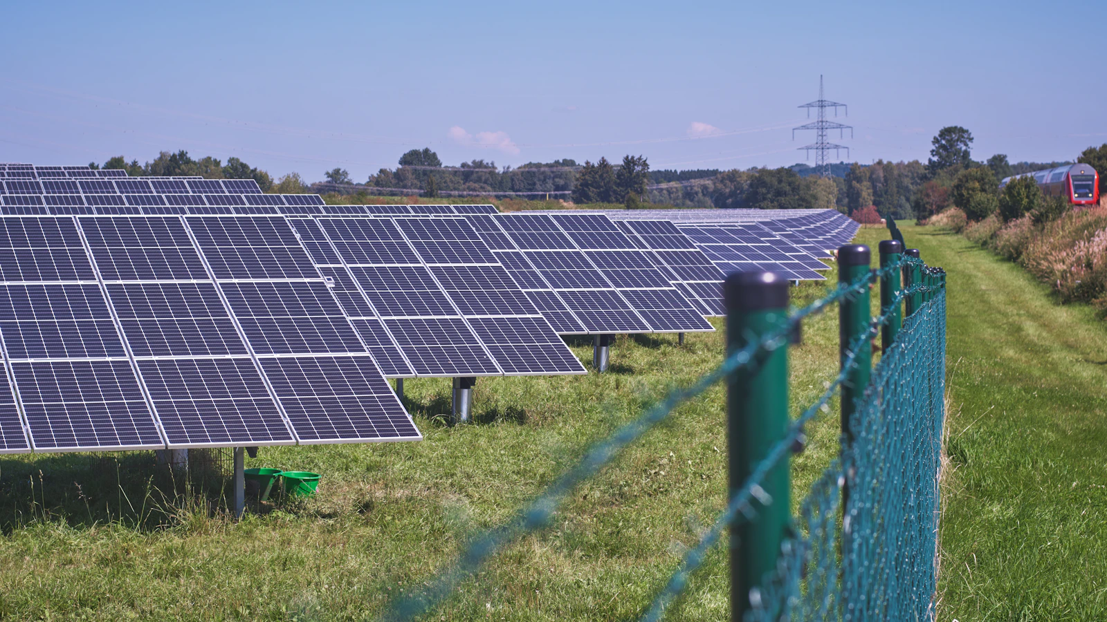 solar panels on green grass field under blue sky during daytime